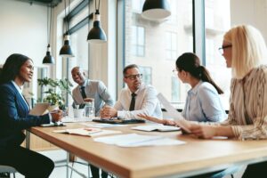 Smiling diverse businesspeople talking together around an office table