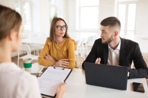 Young business man with laptop and business woman in eyeglasses